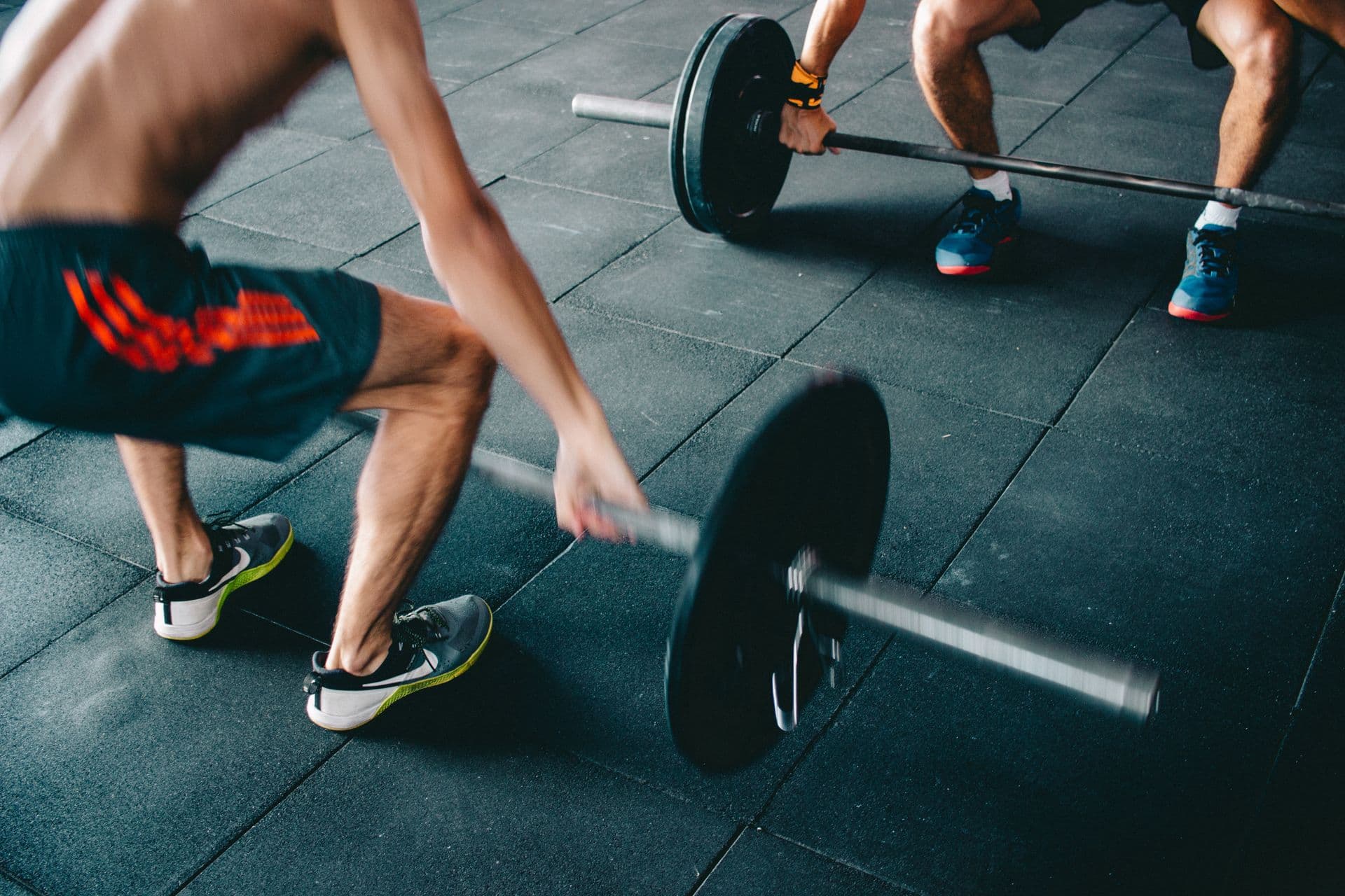 Two athletes moving through a barbell session together