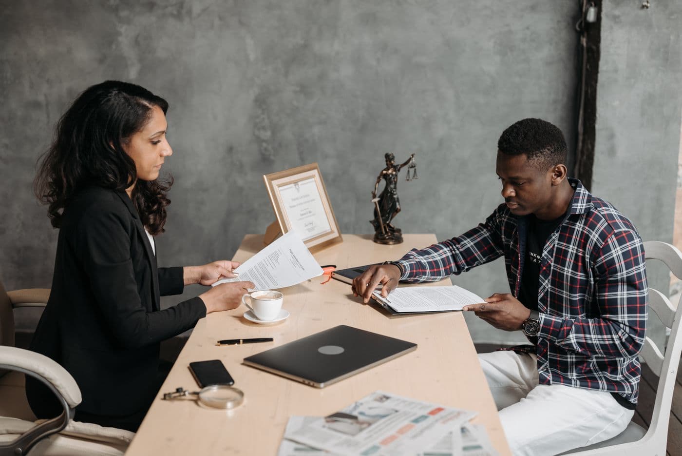 Two people thoughtfully reviewing documents across a desk