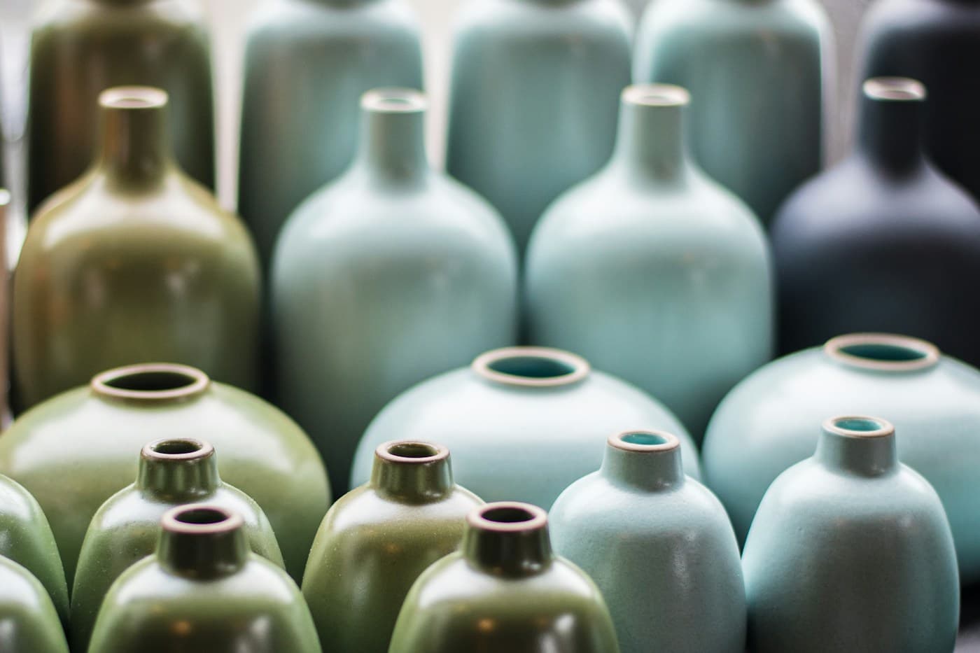 Rounded ceramic vases in sage and blue-green glazes
