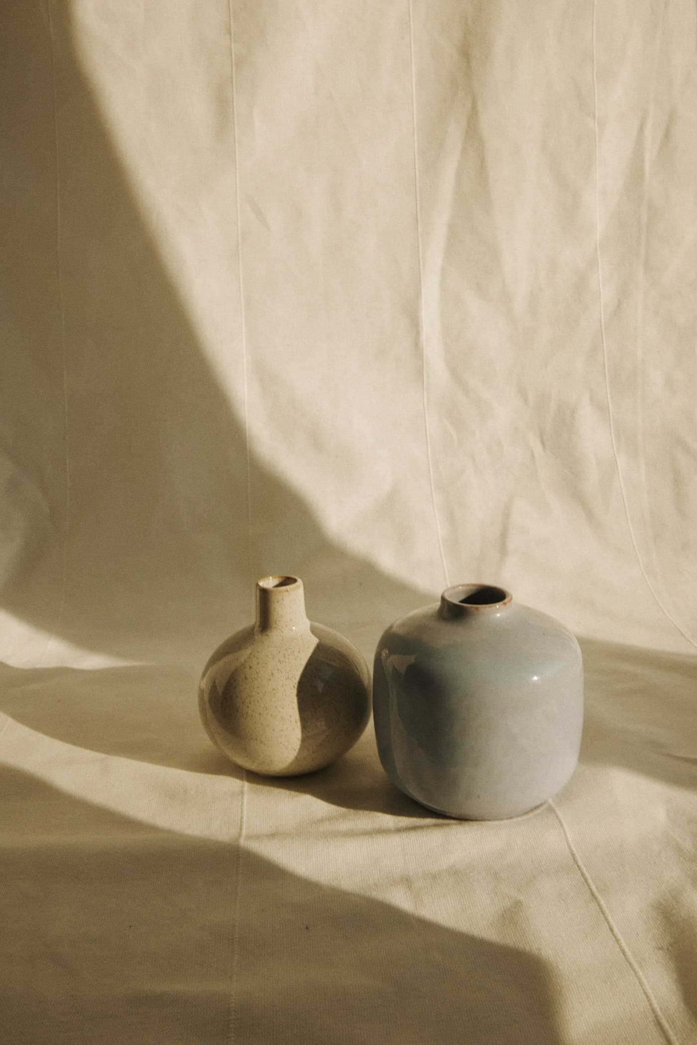 Rounded sand and stone glazed vases in warm sunlight