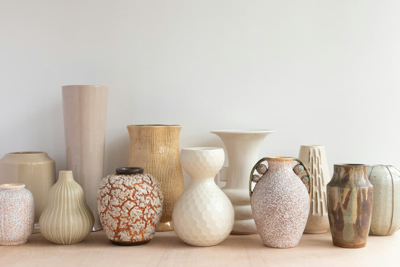 An eclectic group of textured ceramic vases in warm neutral glazes